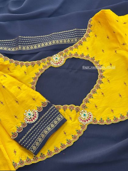 The back of the yellow and navy blouse, featuring a large cutout bordered with matching embroidery.