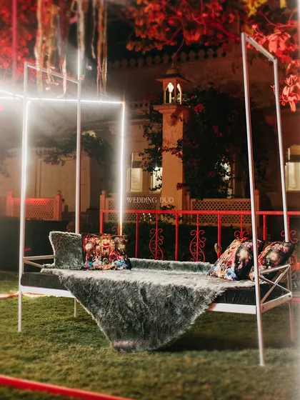 A modern four-poster daybed, illuminated with neon light strips and draped with a faux-fur throw, provided a chic and futuristic lounge spot for guests.