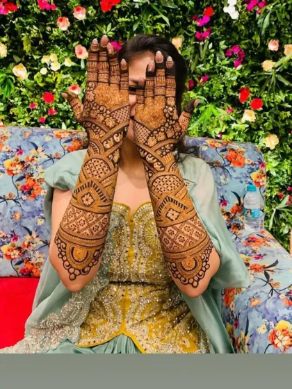 A playful pose from a happy bride, hiding her face behind her beautifully decorated hands.