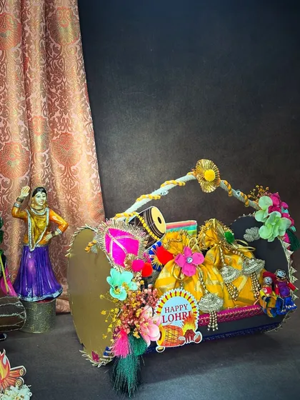 Our first Lohri dhol gift basket, ready to make the celebration memorable. The arrangement includes festive potlis, traditional figurines, and a 'Happy Lohri' tag, all packed with *dher sara pyar*.