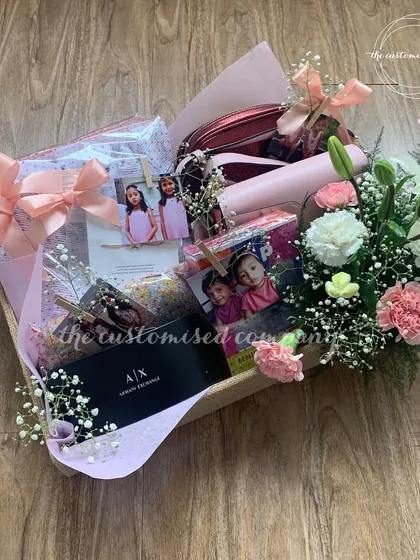 A sweet sixteen or any teenage milestone deserves a special touch. This fresh floral hamper combines beautiful blooms with age-appropriate gifts like an Armani Exchange item and personalized photo displays.