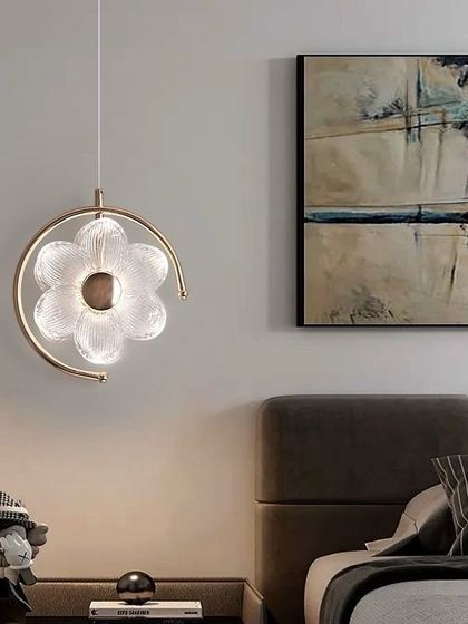 This flower-shaped pendant light, framed by a metal ring, is a perfect bedside lighting solution, adding a touch of elegance and focused light.