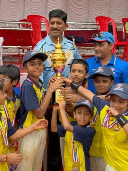 Another one of our winning U-10 teams with their coaches, proudly displaying their championship trophy. The support from our coaching staff is key to their development.