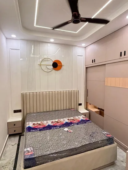 A full view of a bedroom with a fluted headboard, matching wall paneling, and a sliding wardrobe. The cohesive design and neutral tones create a harmonious and modern sleeping space.