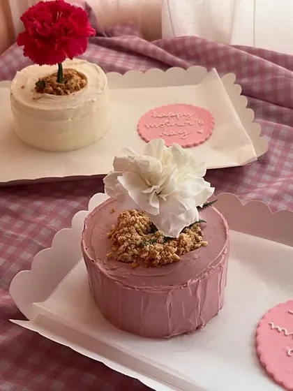 For Mother's Day, I made these super cute flower pot bento cakes. They come with a real carnation on top and a little cookie that says 'Happy Mother's Day'. It’s a sweet and unique way to show your love.