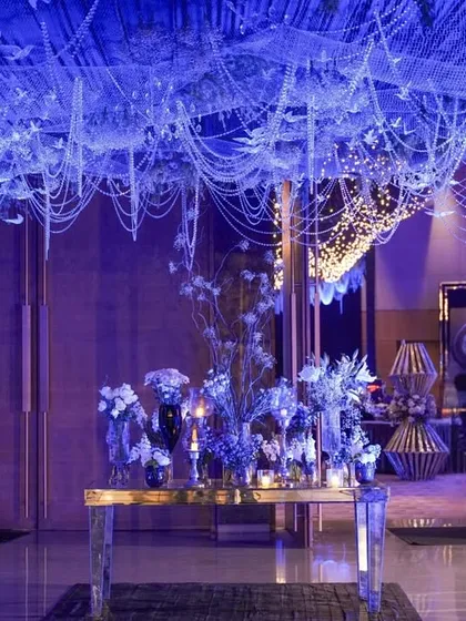 Another view of the whimsical entrance, with the ceiling of pearls and birds creating a beautiful canopy over the floral centerpiece.