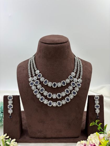 A three-row AD necklace set with square-cut stones. This classic and elegant design is available in all-white, mint green, ruby, blue, and a multi-color option.