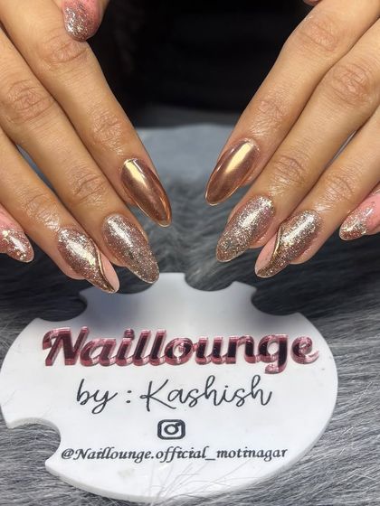 A glamorous combination of rose gold chrome and sparkling gold glitter on almond-shaped nails.