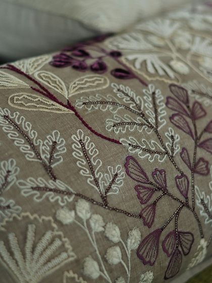 From our 'Ethereal Rose' collection, this cushion features intricate beadwork and embroidery in shades of wine and taupe. The delicate fern-like patterns add a touch of romance and sophistication.