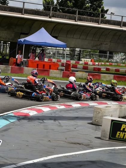 A pack of karts heading into a corner at the ROK Cup Singapore.