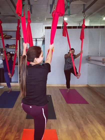 Guiding the group through standing poses using the hammock for balance and support. Private sessions allow for personalized attention and a pace that suits the group's energy.