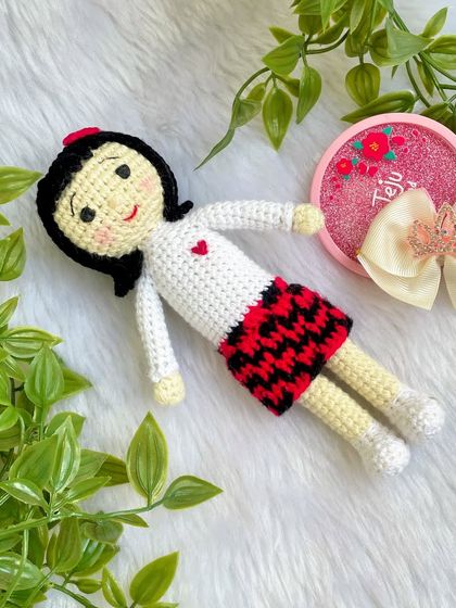 A replica doll of a sweet little girl in a skirt with a red and black pattern. I really enjoyed the challenge of the colorwork on the skirt to make it look just right.