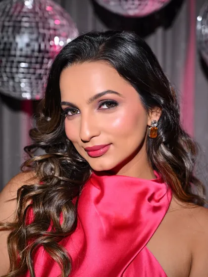 A close-up on the makeup, featuring a sharp eye look and a perfectly matched pink lip.