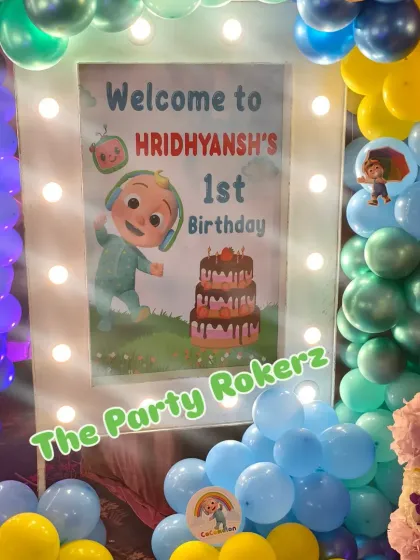 Another example of a lighted welcome sign for a Cocomelon first birthday, surrounded by a colorful balloon arrangement.