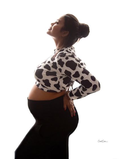 A striking high-key silhouette. This profile shot in a fun, patterned top beautifully emphasizes the shape of the baby bump.