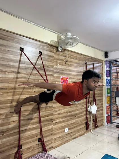 Using wall ropes is a technique I focus on to build exceptional core strength and body control. Here, a student holds a challenging horizontal pose, which decompresses the spine and strengthens the entire back and abdominal muscles. This is not a shortcut, but a tool for achieving correct form.