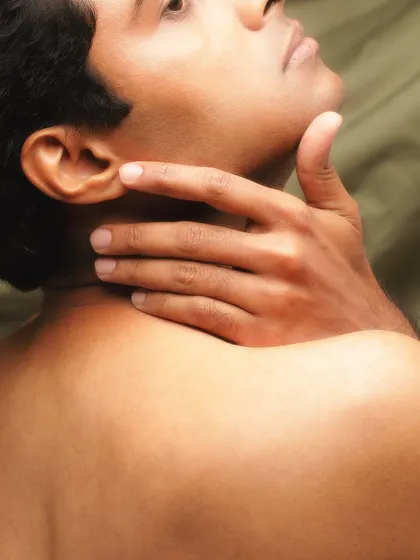 A close-up fine art portrait focusing on the hand and neck. The warm tones and soft lighting create a gentle, tactile image that highlights the simple beauty of the human form.