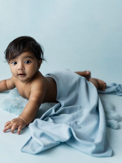 A slightly different angle, with a soft blanket draped over the baby, adding a touch of texture and coziness.