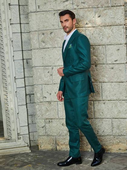 The green linen suit captured in motion. The rich color and tailored fit make it a standout choice for a vacation wardrobe or a special summer event.