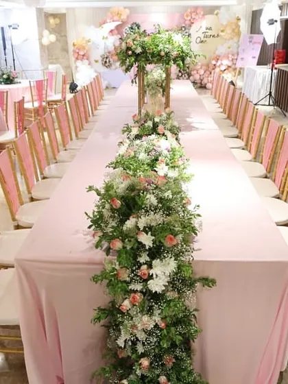 The details make the difference. For this first birthday party, I arranged elegant guest seating with long tables and beautiful floral runners, ensuring the entire venue felt cohesive and every guest felt special.