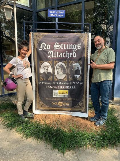 Posing with my collaborator by the show poster for "No Strings Attached." It's a moment of pride and excitement before a performance.
