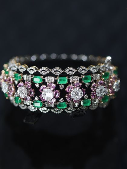 Intricately crafted with endless glamour, this diamond bracelet with emerald and pink stones is a perfect piece to stack or wear as a statement.