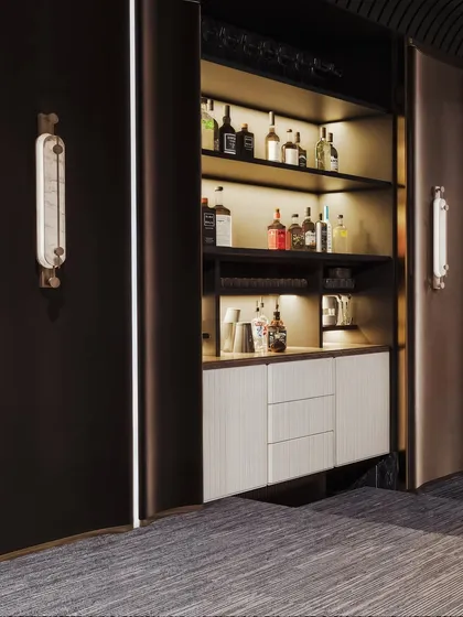 This render reveals a hidden bar cabinet within the entertainment room, complete with backlit shelves to showcase a collection of spirits.