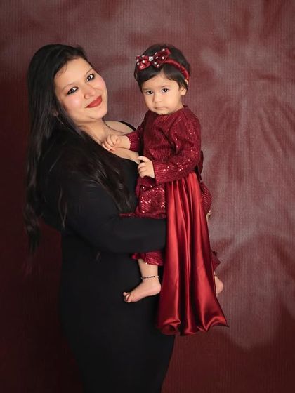 Pure love between a mother and her daughter. The rich red and black outfits against a floral backdrop create a stunning and dramatic portrait.