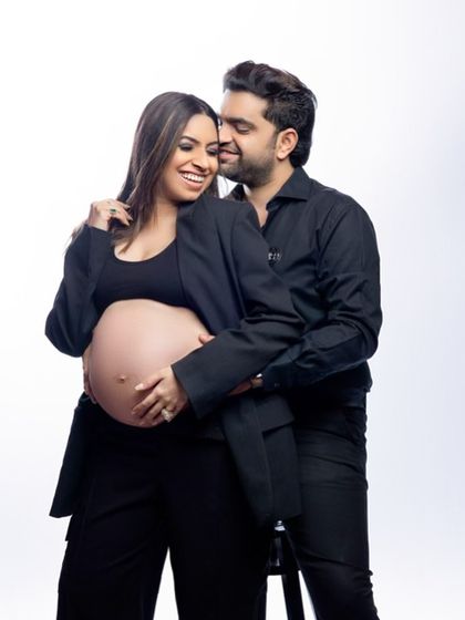 Partnering in parenthood with style. We love this power couple look, with both partners rocking black suits. It's a chic, modern, and confident way to celebrate your journey together.