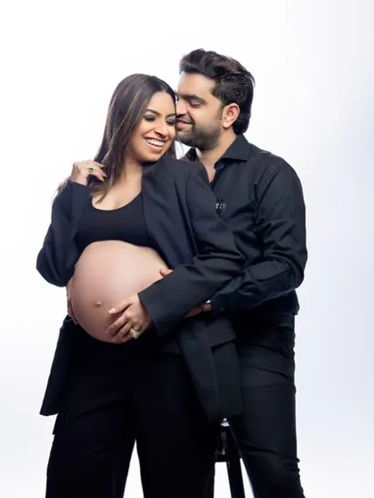Partnering in parenthood with style. We love this power couple look, with both partners rocking black suits. It's a chic, modern, and confident way to celebrate your journey together.