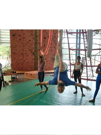 An instructor demonstrates an open-arm inversion, a wonderful pose for opening the chest and shoulders while enjoying the benefits of being upside down.