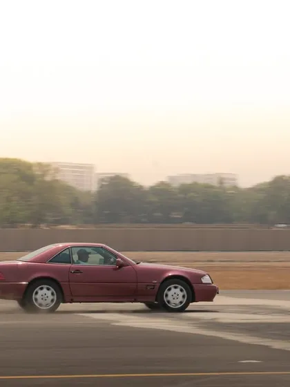 Even classic cars can be captured in motion. This shot shows a vintage red Mercedes convertible sliding on a dusty track, blending elegance with action.