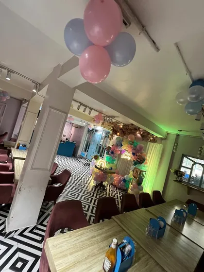 A view of the entire cafe space, showing how the decorations, including ceiling balloons, create a festive party atmosphere.