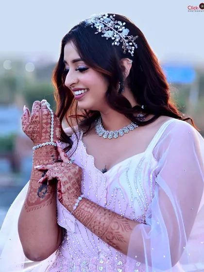 A candid, smiling shot from the same pre-wedding session. This image captures a moment of genuine happiness, showcasing the intricate henna design and sparkling jewelry.