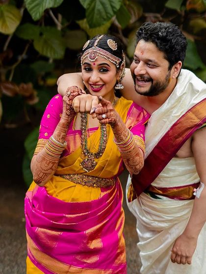 A fun and playful portrait of a couple pointing at each other, full of laughter and personality.