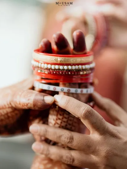 A detail shot of the bride's hands holding her bangles, a mix of Odia and Telugu traditions. Capturing these blended details is key to telling the story of an inter-cultural wedding.