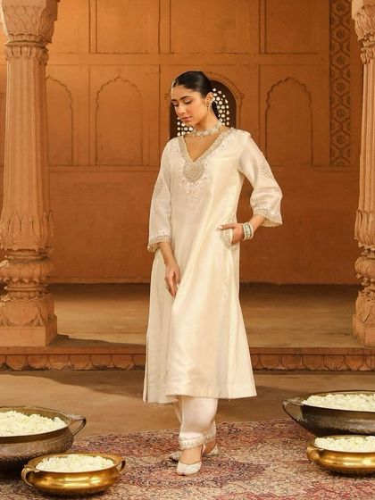 A classic ivory kurta set with delicate silver embroidery, a timeless and elegant choice for any festive occasion.