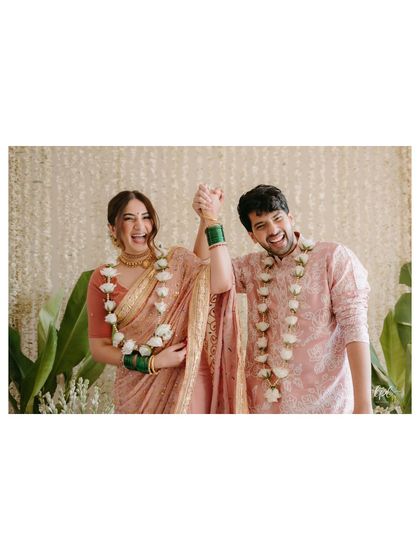 A celebratory moment of the happy couple, hand in hand. The simple floral backdrop with lush green plants provided a fresh, natural setting.