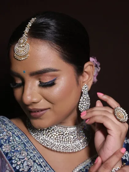 A radiant reception look with a soft brown smokey eye and a pop of blue liner.