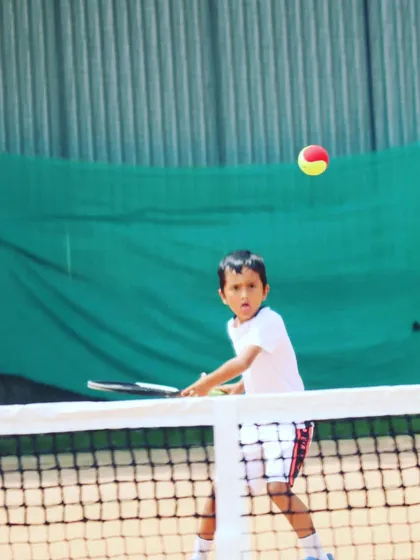 One of our little champs focused on the ball during a volley drill at the net.