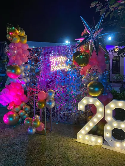 The 28th birthday decor illuminated with pink and purple lights, showing how lighting can transform the mood of the party.