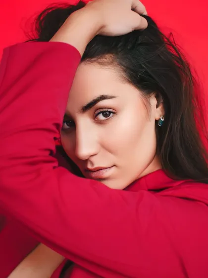 Redefining power and passion. A close-up portrait against a vibrant red background, capturing an intense and confident expression that matches the boldness of the color.