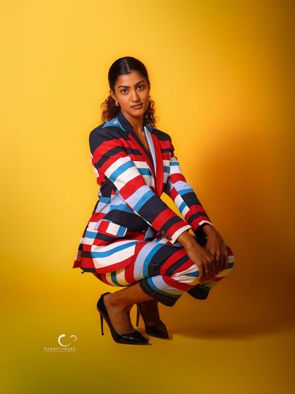 A modern and powerful crouching pose. The composition is tight and focused, emphasizing her strong presence.