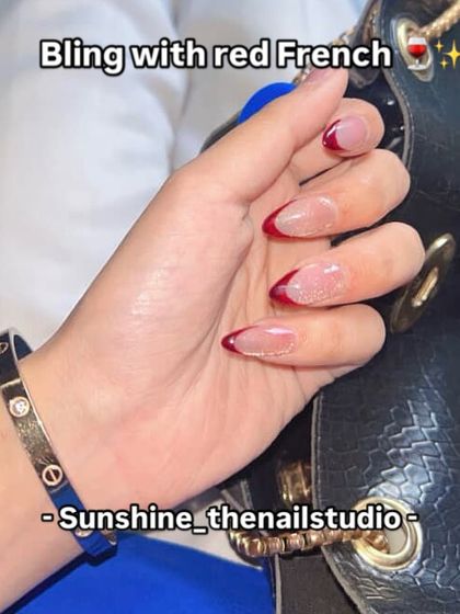 A red French manicure with a glittery base.