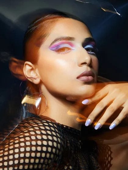 A creative and colorful graphic eye look with a cool shaved-side haircut, captured with a long-exposure light effect.