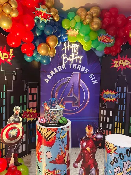 A close-up of our Avengers theme birthday decoration. This view highlights the custom-printed backdrop with the Avengers logo, themed pedestals for the cake, and superhero character standees.