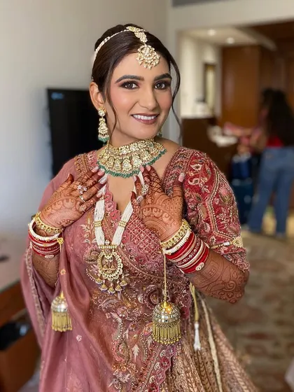 Simran looking absolutely radiant and happy. Her makeup enhances her natural features, giving her a timeless and elegant bridal look.