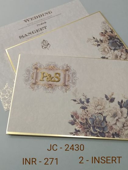 This floral invitation has a gold-trimmed border and a custom 'P&S' monogram. The design is elegant and classic, with matching inserts for a cohesive look.