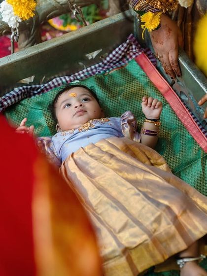 A close-up of the baby looking peaceful in the ceremonial cradle. I make sure to capture the baby's perspective during these important family functions.
