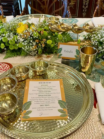 A sit-down feast celebrating India's iconic flavours. The table is set with magnificent brass thaalis, ready for a culinary journey through South Indian, Coastal, and Bengali cuisines.